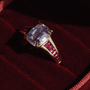 Gold ring with a large old mine cut diamond on a red velvet background