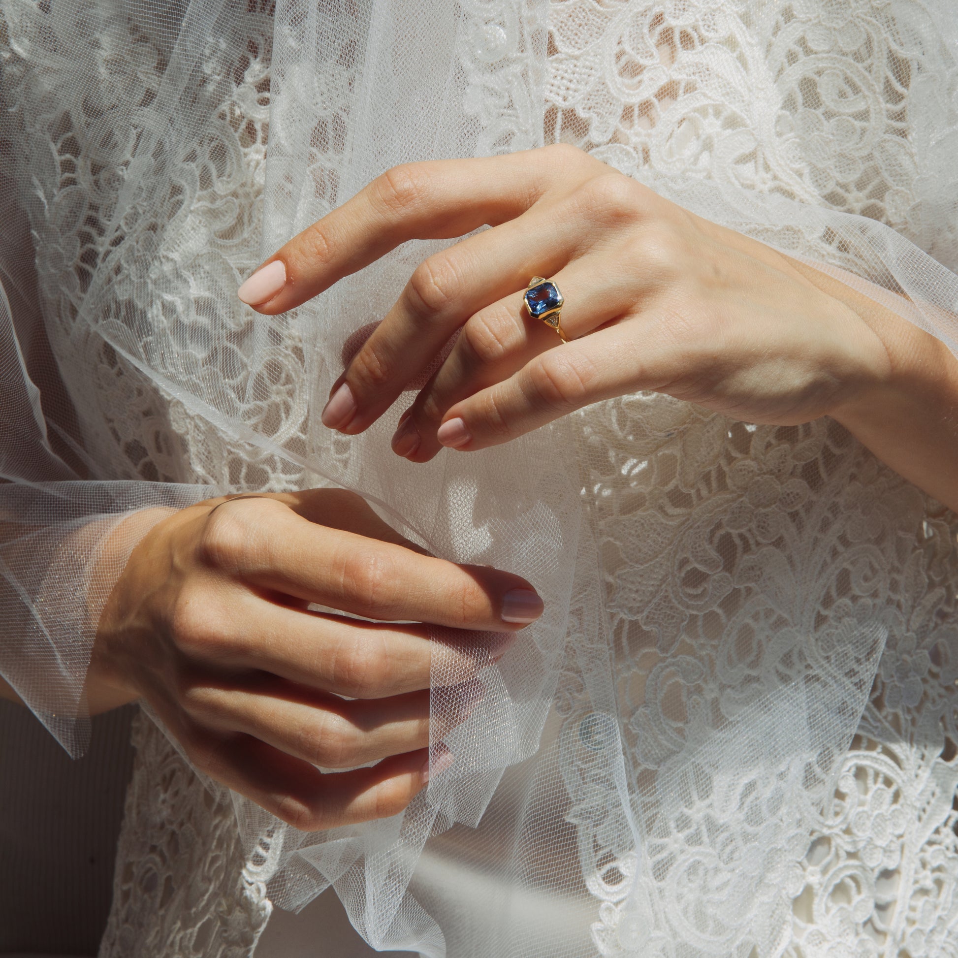Close-up of hands with a ring on a lace fabric background