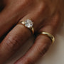 Gold ring with a diamond on a person's finger