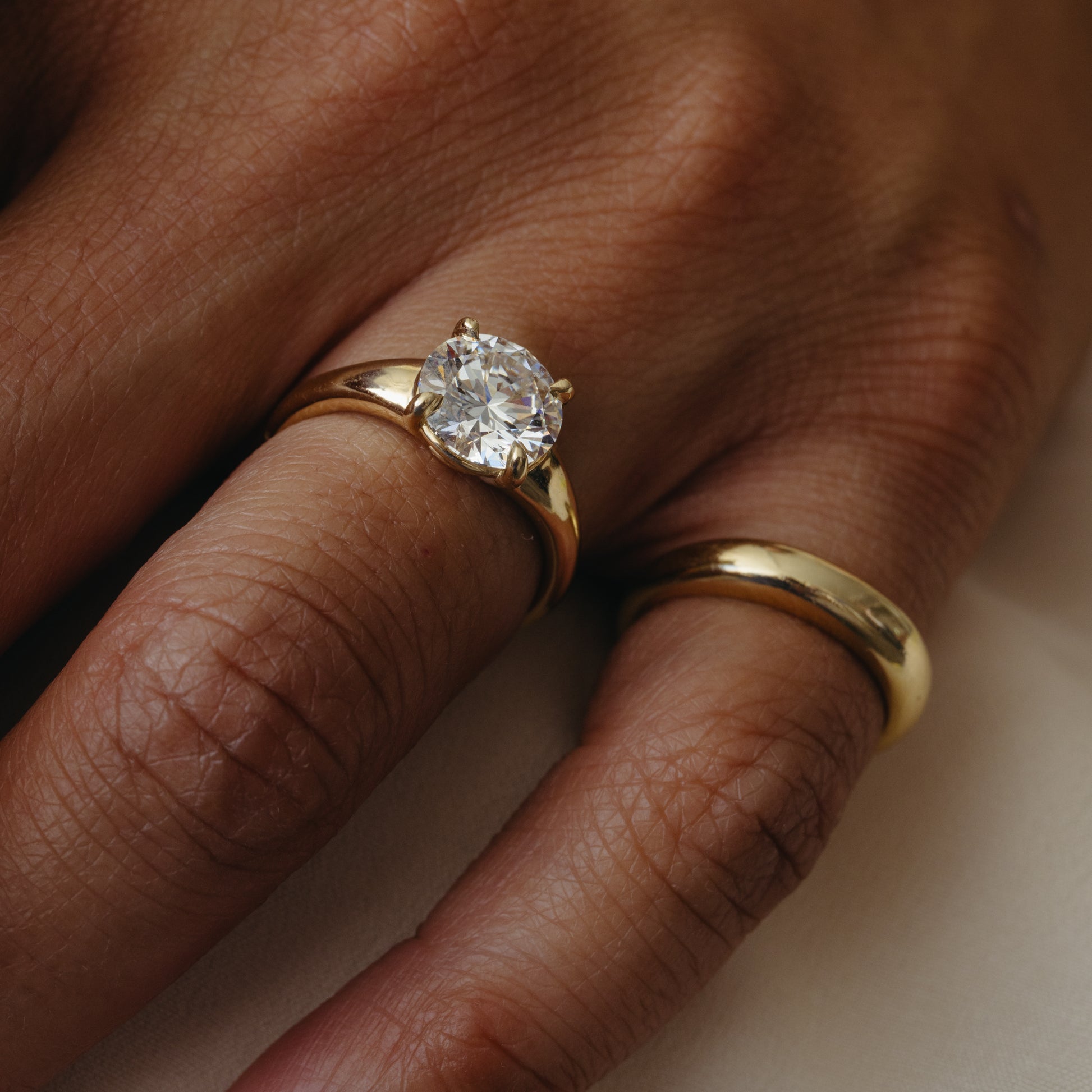 Gold ring with a diamond on a person's finger