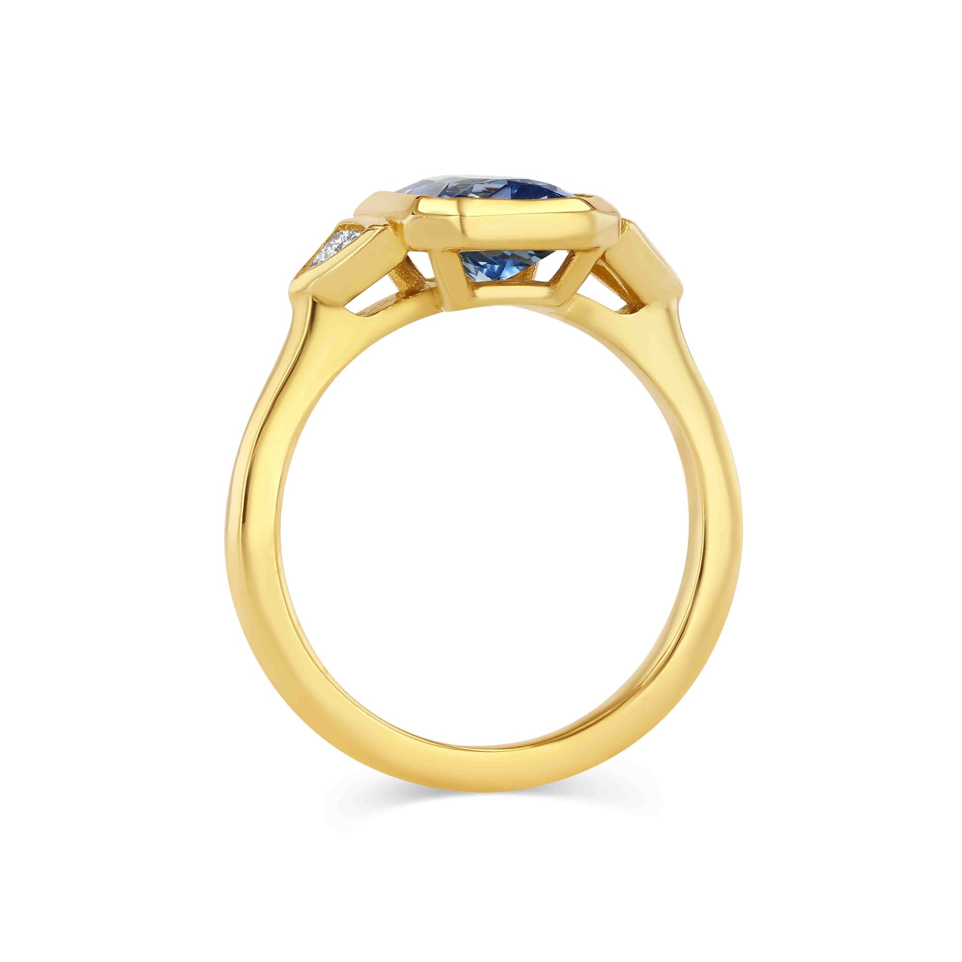 Gold ring with blue gemstone on a white background