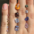 Close-up of a hand with various colored gemstones on fingers